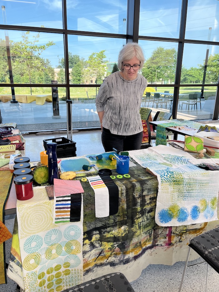 Linda Lindsey in WCC atrium with fabric and stamp