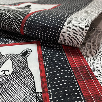 Portion of red, black and white quilt with a bear